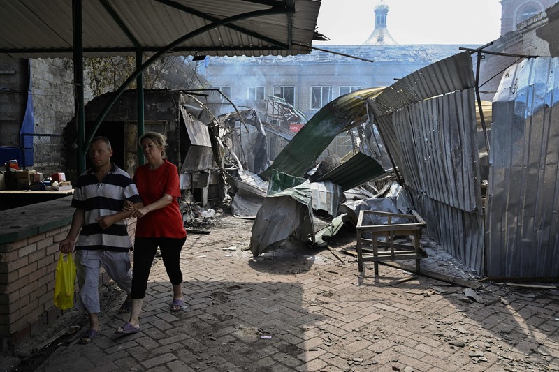 Kondisi pasar lokal Sloviansk, Ukraina sehari setelah serangan roket Rusia Seorang penduduk berjalan di antara puing-puing di samping sebuah rumah yang hancur sehari setelah serangan roket Rusia di pasar lokal Sloviansk, Ukraina, Senin (4/7/2022). Sedikitnya enam orang dilaporkan tewas setelah kota Sloviansk di wilayah Ukraina bagian timur dihantam gempuran kuat Rusia yang diduga menggunakan peluncur roket MLRS. (Photo by GENYA SAVILOV/AFP via Getty Images)