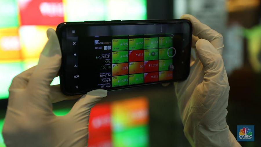 Karyawan melintas di depam layar digital pergerakan Indeks Harga Saham Gabungan (IHSG) di Bursa Efek Indonesia, Jakarta, Selasa (5/7/2022). (վ/ Tri Susilo)