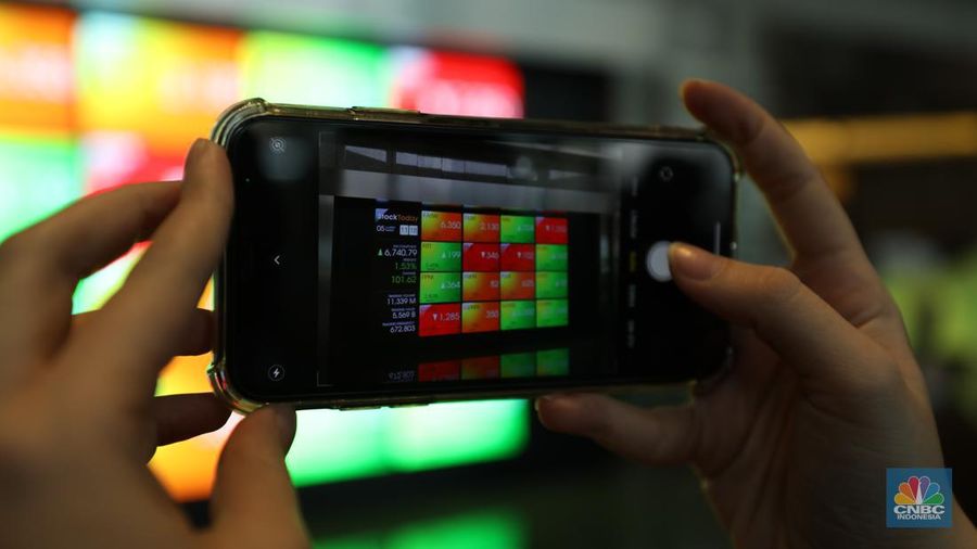 Karyawan melintas di depam layar digital pergerakan Indeks Harga Saham Gabungan (IHSG) di Bursa Efek Indonesia, Jakarta, Selasa (5/7/2022). (վ/ Tri Susilo)