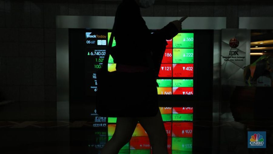 Karyawan melintas di depam layar digital pergerakan Indeks Harga Saham Gabungan (IHSG) di Bursa Efek Indonesia, Jakarta, Selasa (5/7/2022). (վ/ Tri Susilo)