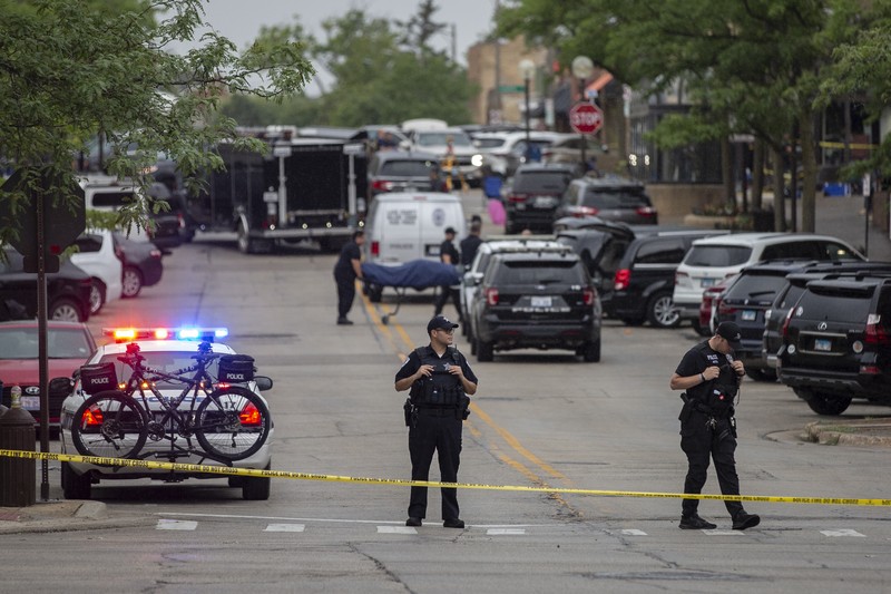 Penembakan Parade Hari Kemerdekaan Amerika Serikat di Highland Park, Chicago, Illinois, AS Polisi memeriksa sebuah bangunan setelah tembakan meletus di rute Parade Hari Kemerdekaan Amerika Serikat di Highland Park, Chicago, Illinois, Amerika Serikat, Senin (4/7/2022). Sebanyak 6 orang dilaporkan tewas akibat penembakan tersebut. (AP Photo/Nam Y. Huh)