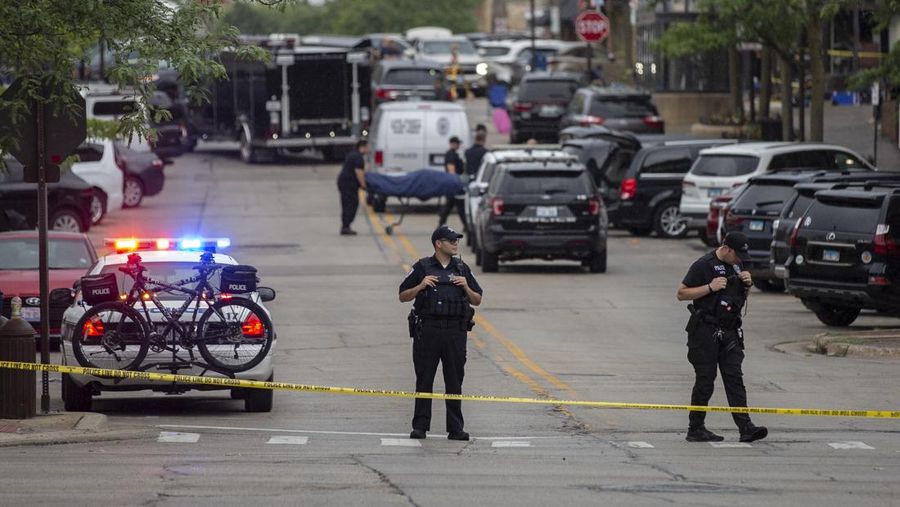 Petugas penyelamat membawa korban setelah tembakan meletus di rute Parade Hari Kemerdekaan Amerika Serikat di Highland Park, pinggiran Chicago, Illinois, Amerika Serikat, Senin (4/7/2022). Sebanyak 6 orang dilaporkan tewas akibat penembakan tersebut. (Photo by Jim Vondruska/Getty Images)