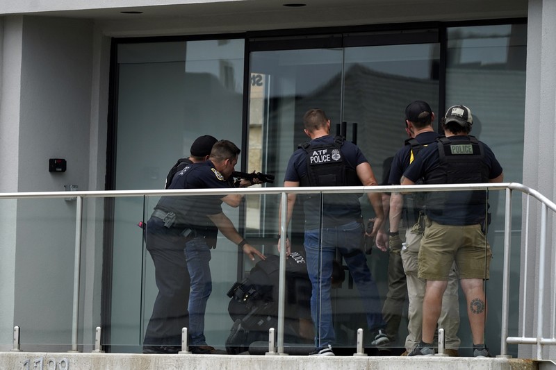 Polisi memeriksa sebuah bangunan setelah tembakan meletus di rute Parade Hari Kemerdekaan Amerika Serikat di Highland Park, Chicago, Illinois, Amerika Serikat, Senin (4/7/2022). Sebanyak 6 orang dilaporkan tewas akibat penembakan tersebut. (AP Photo/Nam Y. Huh)