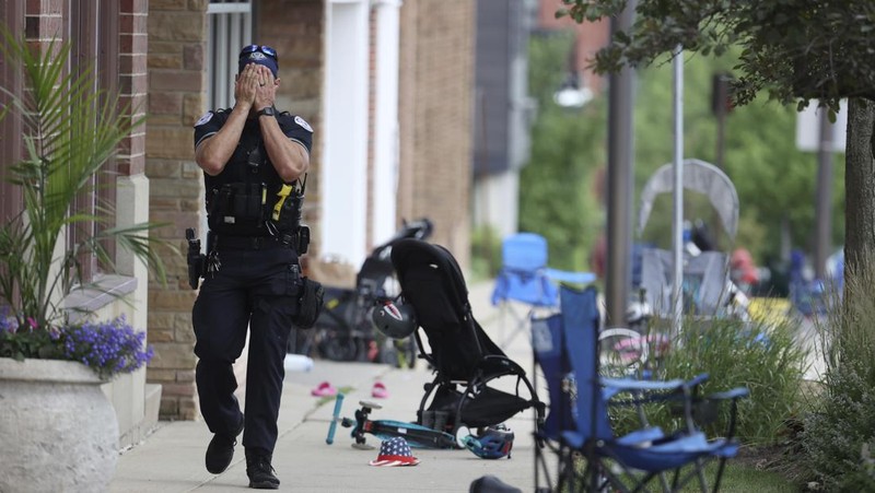 Polisi memeriksa sebuah bangunan setelah tembakan meletus di rute Parade Hari Kemerdekaan Amerika Serikat di Highland Park, Chicago, Illinois, Amerika Serikat, Senin (4/7/2022). Sebanyak 6 orang dilaporkan tewas akibat penembakan tersebut. (AP Photo/Nam Y. Huh)