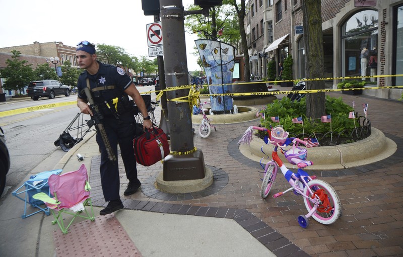 Penembakan Parade Hari Kemerdekaan Amerika Serikat di Highland Park, Chicago, Illinois, AS Polisi memeriksa sebuah bangunan setelah tembakan meletus di rute Parade Hari Kemerdekaan Amerika Serikat di Highland Park, Chicago, Illinois, Amerika Serikat, Senin (4/7/2022). Sebanyak 6 orang dilaporkan tewas akibat penembakan tersebut. (AP Photo/Nam Y. Huh)