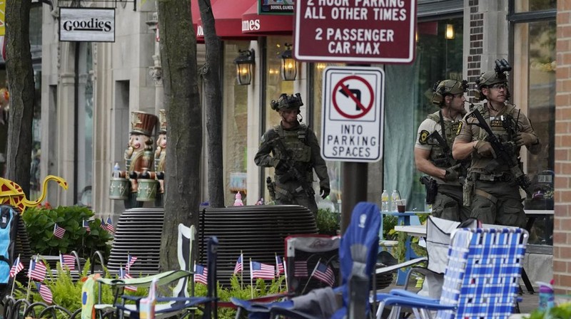 Polisi memeriksa sebuah bangunan setelah tembakan meletus di rute Parade Hari Kemerdekaan Amerika Serikat di Highland Park, Chicago, Illinois, Amerika Serikat, Senin (4/7/2022). Sebanyak 6 orang dilaporkan tewas akibat penembakan tersebut. (AP Photo/Nam Y. Huh)