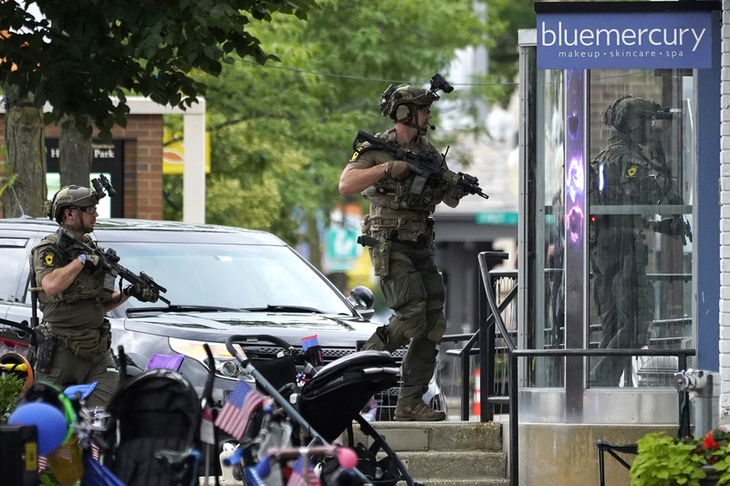 Penembakan Parade Hari Kemerdekaan Amerika Serikat di Highland Park, Chicago, Illinois, AS Polisi memeriksa sebuah bangunan setelah tembakan meletus di rute Parade Hari Kemerdekaan Amerika Serikat di Highland Park, Chicago, Illinois, Amerika Serikat, Senin (4/7/2022). Sebanyak 6 orang dilaporkan tewas akibat penembakan tersebut. (AP Photo/Nam Y. Huh)