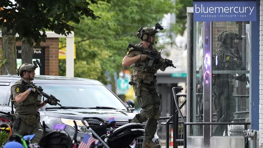 Polisi memeriksa sebuah bangunan setelah tembakan meletus di rute Parade Hari Kemerdekaan Amerika Serikat di Highland Park, Chicago, Illinois, Amerika Serikat, Senin (4/7/2022). Sebanyak 6 orang dilaporkan tewas akibat penembakan tersebut. (AP Photo/Nam Y. Huh)