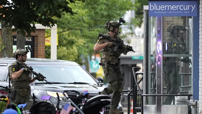 Polisi memeriksa sebuah bangunan setelah tembakan meletus di rute Parade Hari Kemerdekaan Amerika Serikat di Highland Park, Chicago, Illinois, Amerika Serikat, Senin (4/7/2022). Sebanyak 6 orang dilaporkan tewas akibat penembakan tersebut. (AP Photo/Nam Y. Huh)