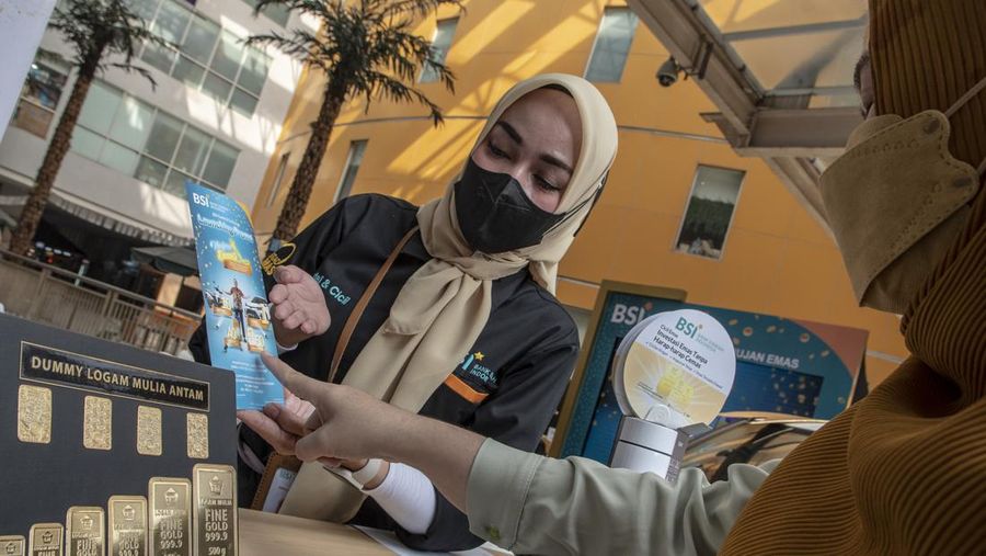 Petugas melayani warga yang akan menabung emas di gerai Gadai Emas dan Cicil Emas BSI di Pasar Mayestik, Kebayoran Baru, Jakarta, Rabu (6/7/2022). Harga emas Antam anjlok sebesar Rp12 ribu per gram, di mana hari sebelumnya harga emas Antam Rp 989 ribu per gram menjadi Rp 977 ribu per gram pada perdagangan Rabu, 6 Juli 2022. ANTARA FOTO/Muhammad Adimaja/foc.