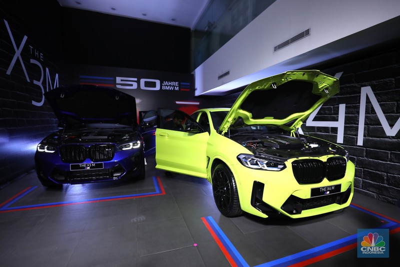 Model berpose dengan latar belakang New BMW X3 M dan BMW X4 M di Jakarta, Kamis (7/7/2022). BMW Indonesia dan BMW Eurokars hadirkan penyegaran model untuk kendaraan performa tinggi di segmen Sports Activity Vehicle (SAV) dan Sports Activity Coupé (SAC) ukuran menengah New BMW X3 M dan BMW X4 M. (CNBC Indonesia/ Tri Susilo)