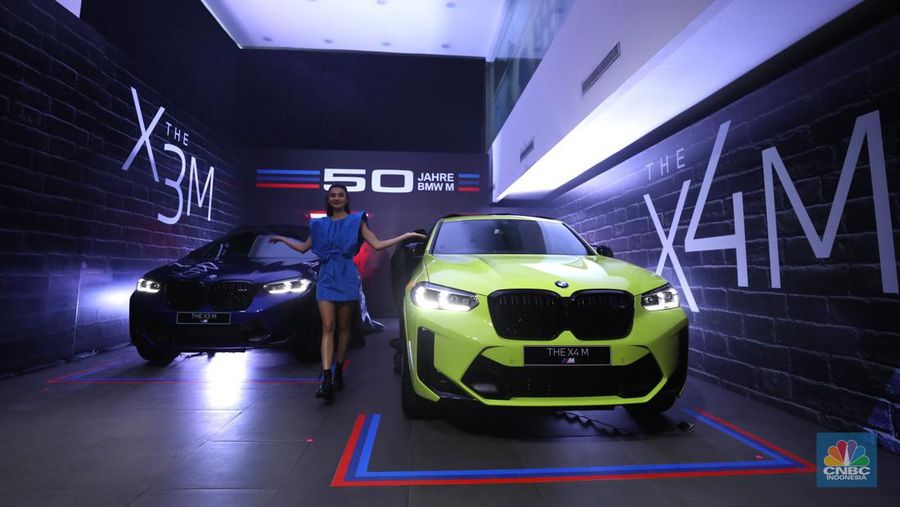 Model berpose dengan latar belakang New BMW X3 M dan BMW X4 M di Jakarta, Kamis (7/7/2022). BMW Indonesia dan BMW Eurokars hadirkan penyegaran model untuk kendaraan performa tinggi di segmen Sports Activity Vehicle (SAV) dan Sports Activity Coupé (SAC) ukuran menengah New BMW X3 M dan BMW X4 M. (CNBC Indonesia/ Tri Susilo)