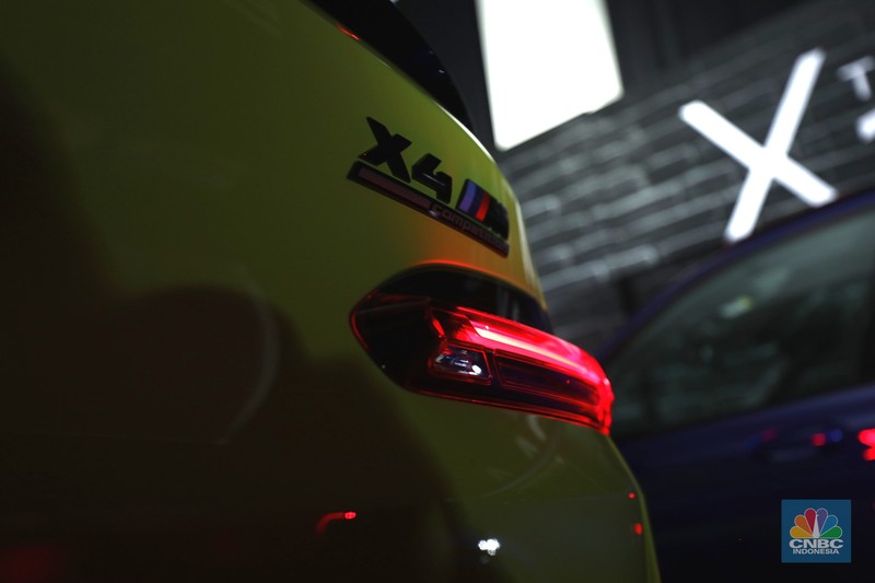 Model berpose dengan latar belakang New BMW X3 M dan BMW X4 M di Jakarta, Kamis (7/7/2022). BMW Indonesia dan BMW Eurokars hadirkan penyegaran model untuk kendaraan performa tinggi di segmen Sports Activity Vehicle (SAV) dan Sports Activity Coupé (SAC) ukuran menengah New BMW X3 M dan BMW X4 M. (CNBC Indonesia/ Tri Susilo)