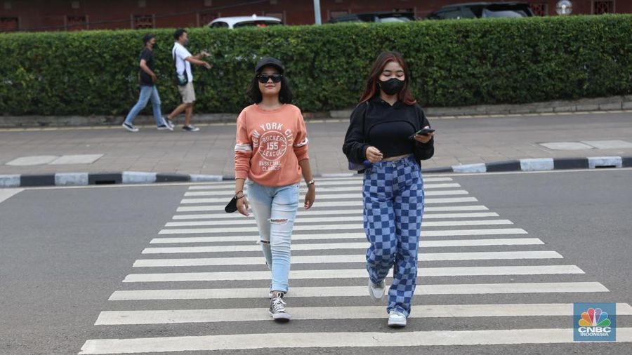 Sejumlah anak muda berjalan di kawasan Taman Sudirman, Jakarta, Kamis (7/7/2022). Tempat ini viral karena jadi ajang adu fashion anak muda yang berasal dari kawasan pinggir wilayah Jakarta seperti Citayam, Bekasi hingga Bojong Gede. (CNBC Indonesia/