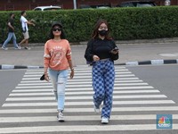 Sejumlah anak muda berjalan di kawasan Taman Sudirman, Jakarta, Kamis (7/7/2022). Tempat ini viral karena jadi ajang adu fashion anak muda yang berasal dari kawasan pinggir wilayah Jakarta seperti Citayam, Bekasi hingga Bojong Gede. (CNBC Indonesia/