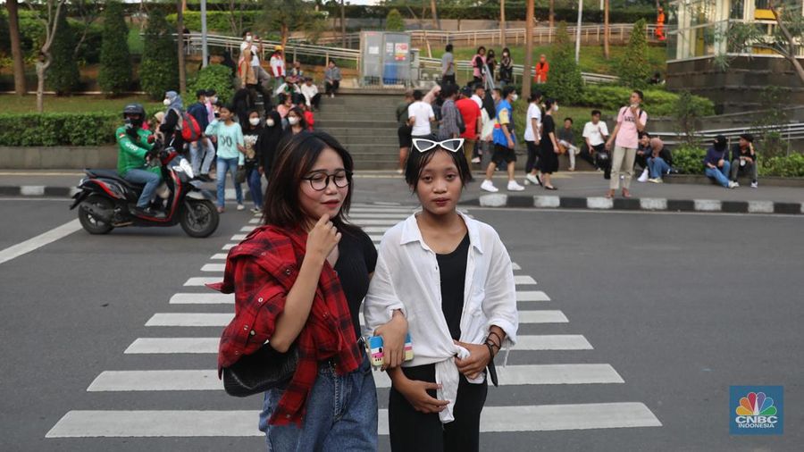 Sejumlah anak muda berjalan di kawasan Taman Sudirman, Jakarta, Kamis (7/7/2022). Tempat ini viral karena jadi ajang adu fashion anak muda yang berasal dari kawasan pinggir wilayah Jakarta seperti Citayam, Bekasi hingga Bojong Gede.(CNBC Indonesia/ Muhammad Sabki)