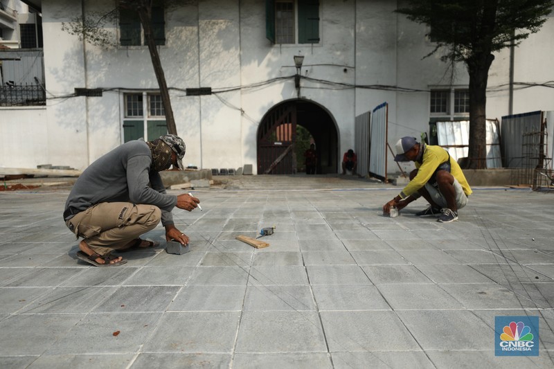 Revitalisasi Kota Tua Pekerja menyelesaikan proyek revitalisasi pedestrian di kawasan Kota Tua, Jakarta, Kamis (7/7/2022). Dinas Bina Marga Provinsi DKI Jakarta mengemukakan pengerjaan revitalisasi trotoar di Kota Tua, Taman Sari, Jakarta Barat, sudah mencapai 80 persen dan direncanakan selesai di akhir bulan Juli 2022. (CNBC Indoesia/ Tri Susilo)