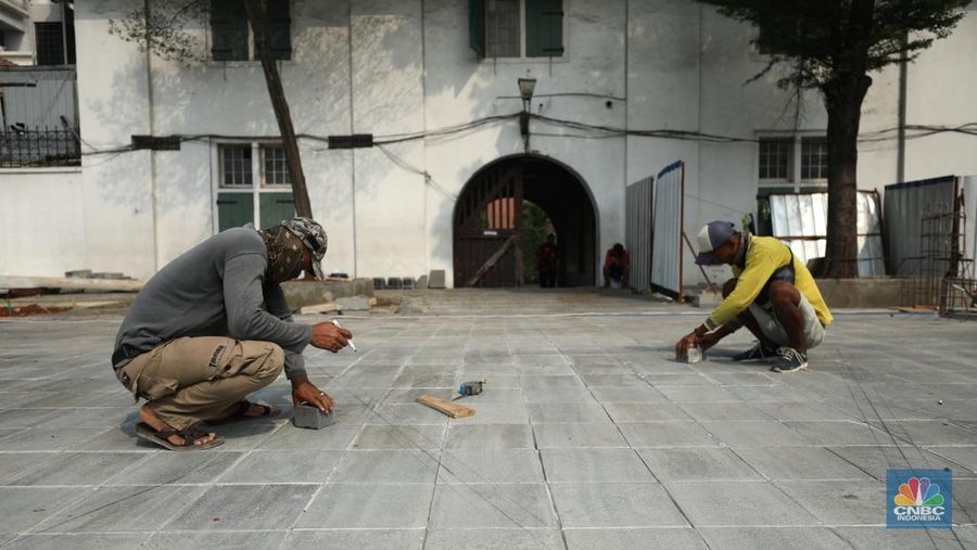 Pekerja menyelesaikan proyek revitalisasi pedestrian di kawasan Kota Tua, Jakarta, Kamis  (7/7/2022). Dinas Bina Marga Provinsi DKI Jakarta mengemukakan pengerjaan revitalisasi trotoar di Kota Tua, Taman Sari, Jakarta Barat, sudah mencapai 80 persen dan direncanakan selesai di akhir bulan Juli 2022. (CNBC Indoesia/ Tri Susilo)