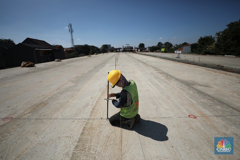 Pekerja menyelesaikan pembangunan Tol Cinere - Jagorawi (Cijago) seksi III di Beji, Depok, Jawa Barat, Jumat (8/7/2022). Jalan tol tersebut merupakan bagian dari jaringan Jalan Tol Jakarta Outer Ring Road atau JORR II yang menghubungkan Kukusan–Cinere Depok sepanjang 5,5 kilometer. (CNBC Indoneia/ Tri Susilo)