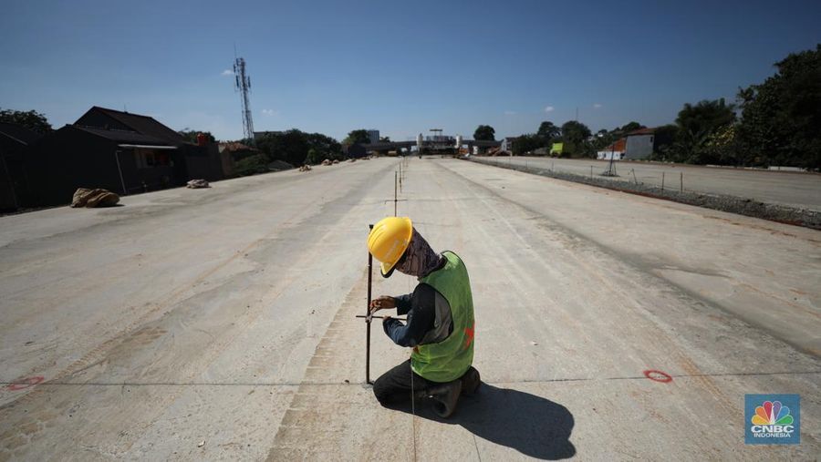 Pekerja menyelesaikan pembangunan Tol Cinere - Jagorawi (Cijago) seksi III di Beji, Depok, Jawa Barat, Jumat (8/7/2022). Jalan tol tersebut merupakan bagian dari jaringan Jalan Tol Jakarta Outer Ring Road atau JORR II yang menghubungkan Kukusan–Cinere Depok sepanjang 5,5 kilometer. (CNBC Indoneia/ Tri Susilo)