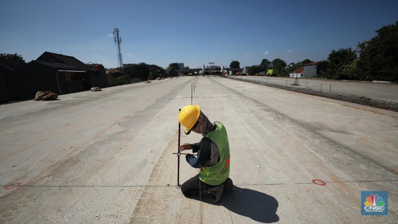 Pekerja menyelesaikan pembangunan Tol Cinere - Jagorawi (Cijago) seksi III di Beji, Depok, Jawa Barat, Jumat (8/7/2022). Jalan tol tersebut merupakan bagian dari jaringan Jalan Tol Jakarta Outer Ring Road atau JORR II yang menghubungkan Kukusan–Cinere Depok sepanjang 5,5 kilometer. (CNBC Indoneia/ Tri Susilo)