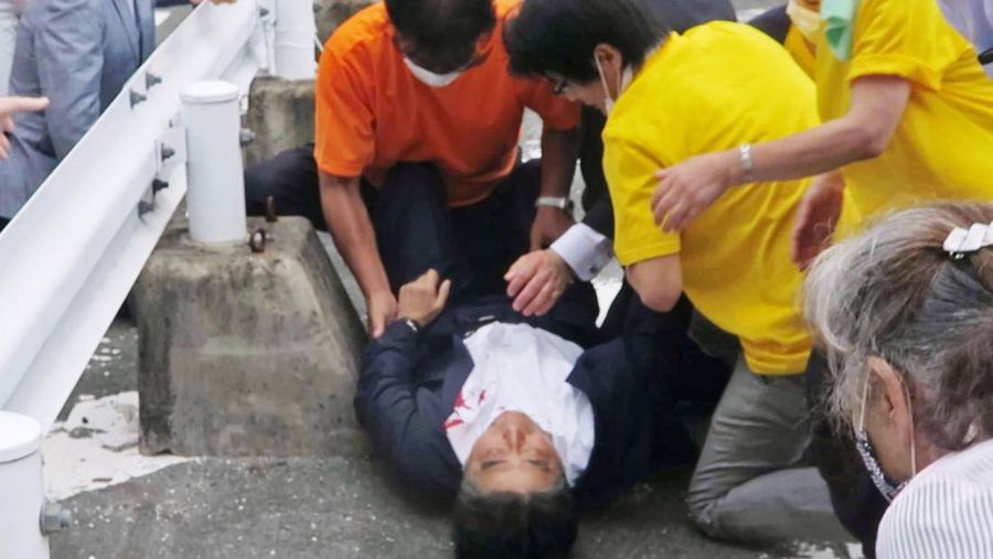 Mantan Perdana Menteri Jepang Shinzo Abe (tengah)  jatuh ke tanah di Nara, Jepang, Jumat (8/7/2022). Abe ditembak saat pidato kampanye Jumat di Jepang barat dan ditbawa ke rumah sakit tetapi dia tidak bernapas dan jantungnya berhenti, kata para pejabat. (Kyodo News via AP)