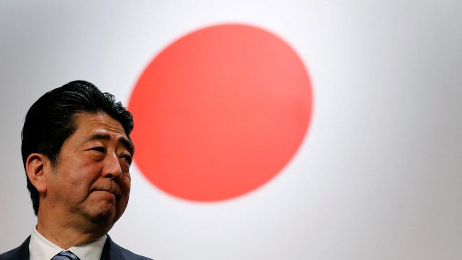 FILE PHOTO: Japan's Prime Minister Shinzo Abe stands in front of Japan's national flag after his ruling Liberal Democratic Party's (LDP) annual party convention in Tokyo, Japan, March 5, 2017.  REUTERS/Toru Hanai/File Photo