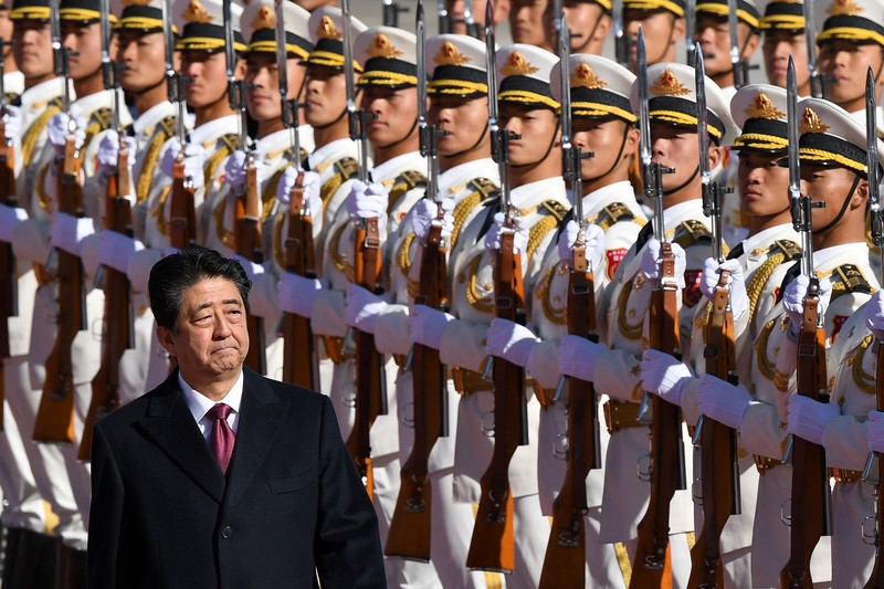 Perdana Menteri Jepang Shinzo Abe meninjau pengawal kehormatan militer dengan Perdana Menteri China Li Keqiang (tidak digambarkan) saat upacara penyambutan di luar Aula Besar Rakyat di Beijing pada 26 Oktober 2018.  (Photo by GREG BAKER/AFP via Getty Images)