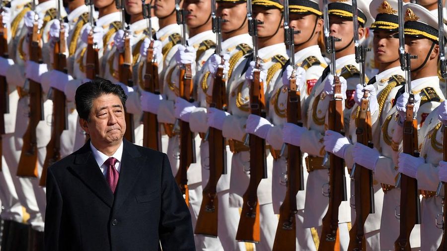Perdana Menteri Jepang Shinzo Abe meninjau pengawal kehormatan militer dengan Perdana Menteri China Li Keqiang (tidak digambarkan) saat upacara penyambutan di luar Aula Besar Rakyat di Beijing pada 26 Oktober 2018.  (Photo by GREG BAKER/AFP via Getty Images)