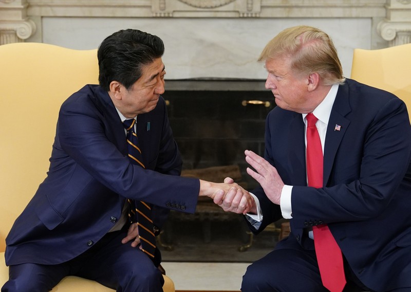 Perdana Menteri Jepang Shinzo Abe meninjau pengawal kehormatan militer dengan Perdana Menteri China Li Keqiang (tidak digambarkan) saat upacara penyambutan di luar Aula Besar Rakyat di Beijing pada 26 Oktober 2018.  (Photo by GREG BAKER/AFP via Getty Images)