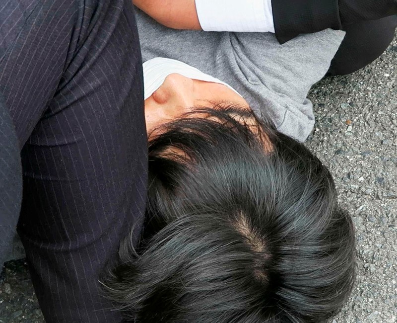 Former Japanese prime minister Shinzo Abe lies on the ground after apparent shooting during an election campaign for the July 10, 2022 Upper House election, in Nara, western Japan July 8, 2022. in this photo taken by Kyodo. Mandatory credit Kyodo via REUTERS ATTENTION EDITORS - THIS IMAGE WAS PROVIDED BY A THIRD PARTY. MANDATORY CREDIT. JAPAN OUT. NO COMMERCIAL OR EDITORIAL SALES IN JAPAN.