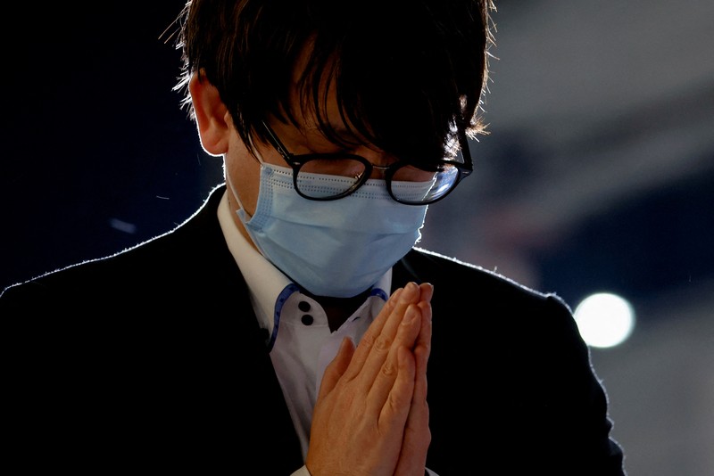 People pray at a makeshift memorial at the scene where the former Prime Minister Shinzo Abe was shot while delivering his speech to support the Liberal Democratic Party's candidate during an election campaign in Nara, Friday, July 8, 2022.  Abe, a divisive arch-conservative and one of his nation's most powerful and influential figures, has died after being shot during a campaign speech Friday in western Japan, hospital officials said.(Kyodo News via AP)