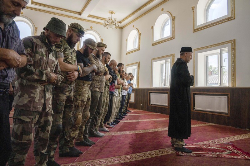 Russia Ukraine War Eid al-Adha Former Mufti-turned-fighter Sheikh Said Ismahilov, right, leads Muslim soldiers during prayers on the first day of Eid al-Adha, in Medina Mosque, Konstantinovka, eastern Ukraine, Saturday, July 9, 2022. Muslims around the world celebrate Eid al-Adha by sacrificing animals to commemorate the prophet Ibrahim's faith in being willing to sacrifice his son. (AP Photo/Nariman El-Mofty)