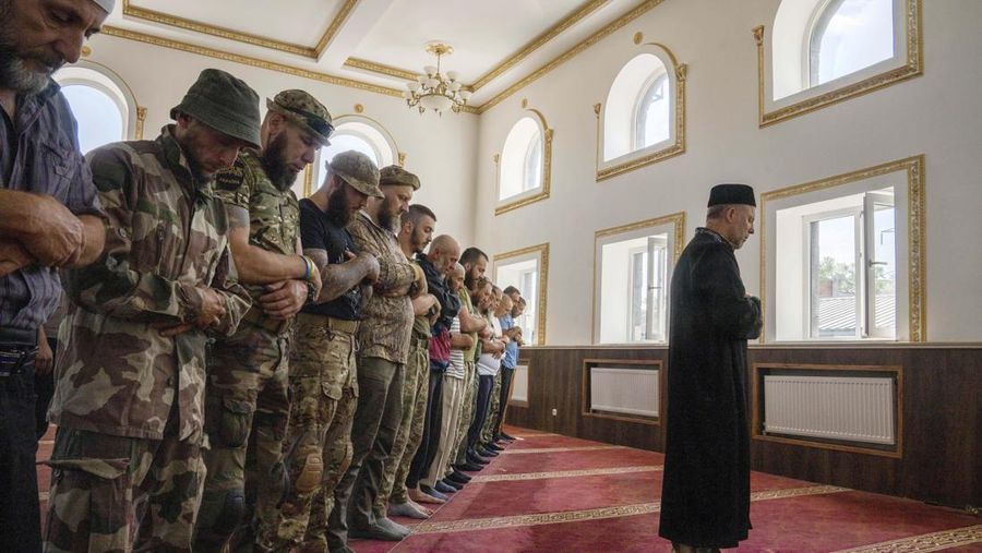 Former Mufti-turned-fighter Sheikh Said Ismahilov, right, leads Muslim soldiers during prayers on the first day of Eid al-Adha, in Medina Mosque, Konstantinovka, eastern Ukraine, Saturday, July 9, 2022. Muslims around the world celebrate Eid al-Adha by sacrificing animals to commemorate the prophet Ibrahim's faith in being willing to sacrifice his son. (AP Photo/Nariman El-Mofty)