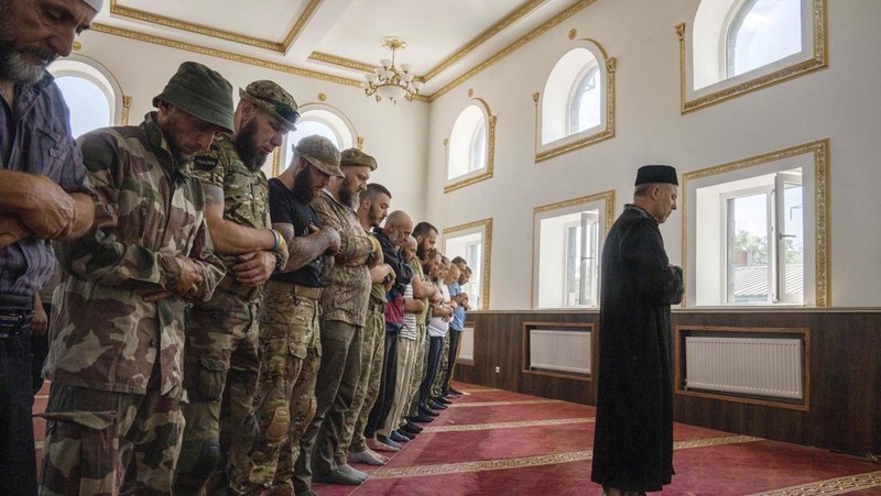 Former Mufti-turned-fighter Sheikh Said Ismahilov, right, leads Muslim soldiers during prayers on the first day of Eid al-Adha, in Medina Mosque, Konstantinovka, eastern Ukraine, Saturday, July 9, 2022. Muslims around the world celebrate Eid al-Adha by sacrificing animals to commemorate the prophet Ibrahim's faith in being willing to sacrifice his son. (AP Photo/Nariman El-Mofty)