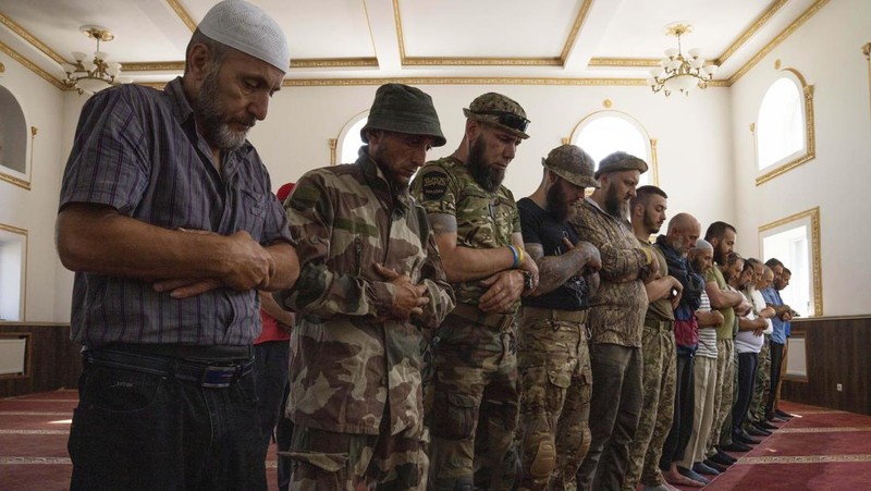 Former Mufti-turned-fighter Sheikh Said Ismahilov, right, leads Muslim soldiers during prayers on the first day of Eid al-Adha, in Medina Mosque, Konstantinovka, eastern Ukraine, Saturday, July 9, 2022. Muslims around the world celebrate Eid al-Adha by sacrificing animals to commemorate the prophet Ibrahim's faith in being willing to sacrifice his son. (AP Photo/Nariman El-Mofty)