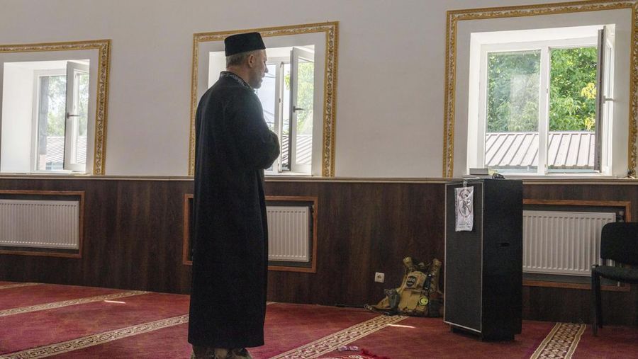 Former Mufti-turned-fighter Sheikh Said Ismahilov, right, leads Muslim soldiers during prayers on the first day of Eid al-Adha, in Medina Mosque, Konstantinovka, eastern Ukraine, Saturday, July 9, 2022. Muslims around the world celebrate Eid al-Adha by sacrificing animals to commemorate the prophet Ibrahim's faith in being willing to sacrifice his son. (AP Photo/Nariman El-Mofty)