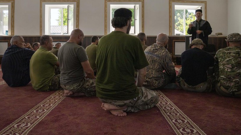 Former Mufti-turned-fighter Sheikh Said Ismahilov, right, leads Muslim soldiers during prayers on the first day of Eid al-Adha, in Medina Mosque, Konstantinovka, eastern Ukraine, Saturday, July 9, 2022. Muslims around the world celebrate Eid al-Adha by sacrificing animals to commemorate the prophet Ibrahim's faith in being willing to sacrifice his son. (AP Photo/Nariman El-Mofty)
