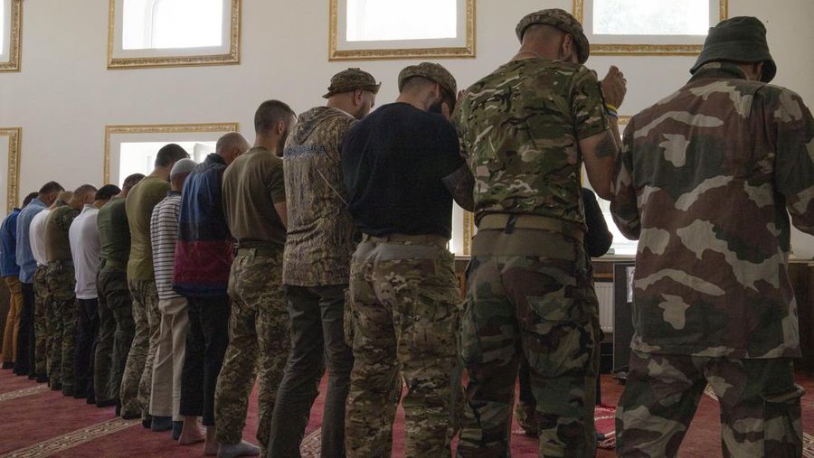 Former Mufti-turned-fighter Sheikh Said Ismahilov, right, leads Muslim soldiers during prayers on the first day of Eid al-Adha, in Medina Mosque, Konstantinovka, eastern Ukraine, Saturday, July 9, 2022. Muslims around the world celebrate Eid al-Adha by sacrificing animals to commemorate the prophet Ibrahim's faith in being willing to sacrifice his son. (AP Photo/Nariman El-Mofty)