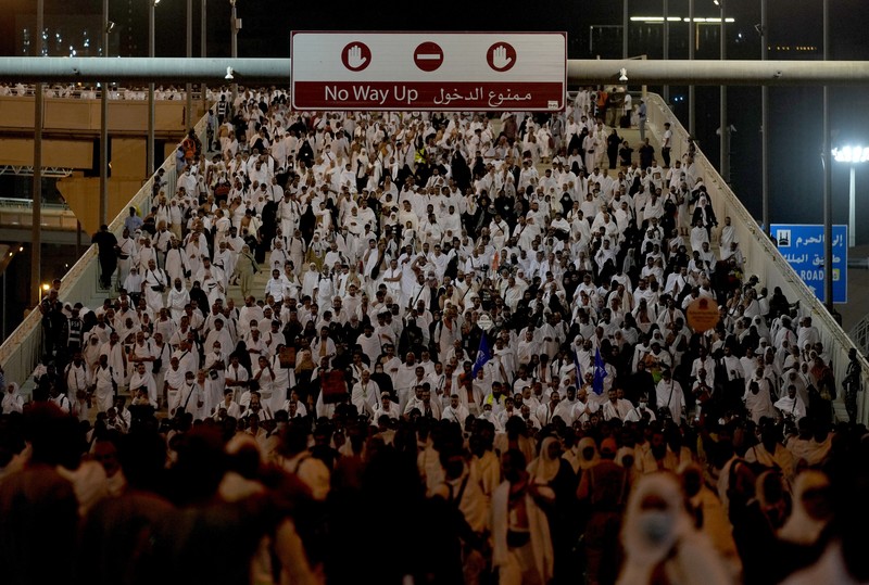 Muslim pilgrims walk to cast stones at a pillar in the symbolic stoning of the devil, during the last rite of the annual hajj, and the first day of Eid al-Adha, in Mina near the city of Mecca, Saudi Arabia, Saturday, July 9, 2022. (AP Photo/Amr Nabil)
