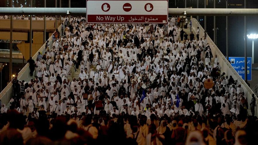 Muslim pilgrims walk to cast stones at a pillar in the symbolic stoning of the devil, during the last rite of the annual hajj, and the first day of Eid al-Adha, in Mina near the city of Mecca, Saudi Arabia, Saturday, July 9, 2022. (AP Photo/Amr Nabil)