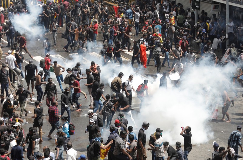 SRI LANKA-CRISIS/ Demonstrators run from tear gas used by police during a protest demanding the resignation of President Gotabaya Rajapaksa, amid the country's economic crisis, near the president's residence in Colombo, Sri Lanka, July 9, 2022. REUTERS/Dinuka Liyanawatte