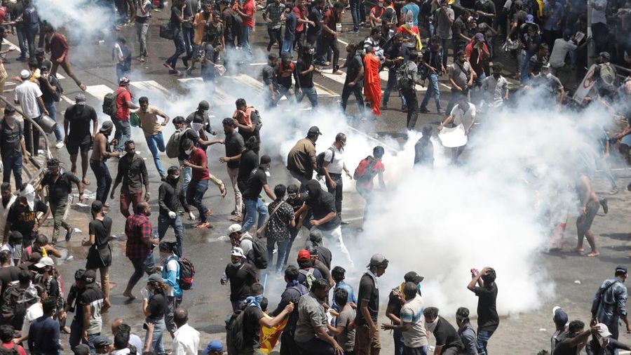 Demonstrators run from tear gas used by police during a protest demanding the resignation of President Gotabaya Rajapaksa, amid the country's economic crisis, near the president's residence in Colombo, Sri Lanka, July 9, 2022. REUTERS/Dinuka Liyanawatte