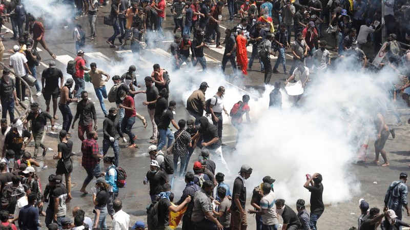 Demonstrators run from tear gas used by police during a protest demanding the resignation of President Gotabaya Rajapaksa, amid the country's economic crisis, near the president's residence in Colombo, Sri Lanka, July 9, 2022. REUTERS/Dinuka Liyanawatte