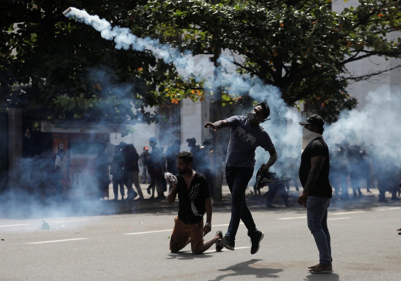 SRI LANKA-CRISIS/ Demonstrators run from tear gas used by police during a protest demanding the resignation of President Gotabaya Rajapaksa, amid the country's economic crisis, near the president's residence in Colombo, Sri Lanka, July 9, 2022. REUTERS/Dinuka Liyanawatte