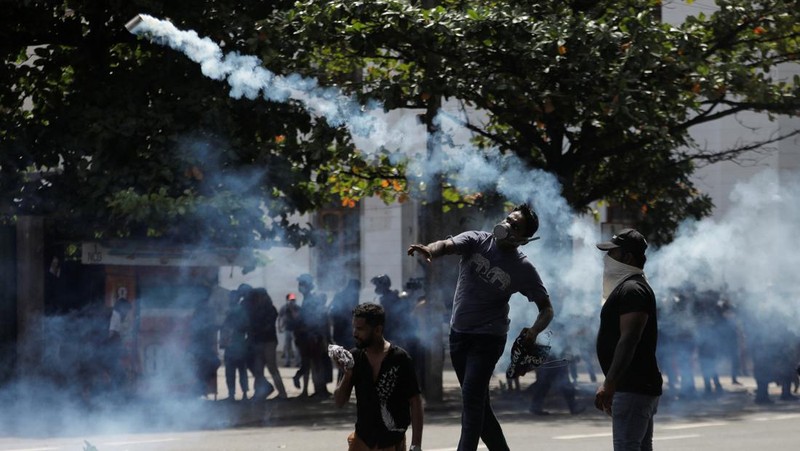 Demonstrators run from tear gas used by police during a protest demanding the resignation of President Gotabaya Rajapaksa, amid the country's economic crisis, near the president's residence in Colombo, Sri Lanka, July 9, 2022. REUTERS/Dinuka Liyanawatte