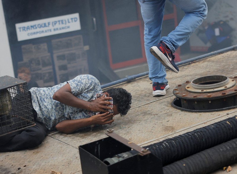 SRI LANKA-CRISIS/ Demonstrators run from tear gas used by police during a protest demanding the resignation of President Gotabaya Rajapaksa, amid the country's economic crisis, near the president's residence in Colombo, Sri Lanka, July 9, 2022. REUTERS/Dinuka Liyanawatte
