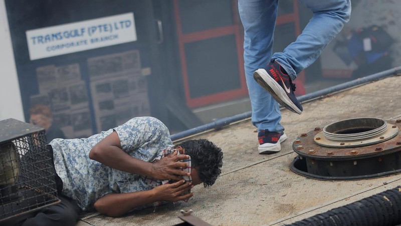 Demonstrators run from tear gas used by police during a protest demanding the resignation of President Gotabaya Rajapaksa, amid the country's economic crisis, near the president's residence in Colombo, Sri Lanka, July 9, 2022. REUTERS/Dinuka Liyanawatte