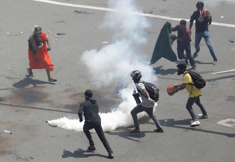 Demonstrators run from tear gas used by police during a protest demanding the resignation of President Gotabaya Rajapaksa, amid the country's economic crisis, near the president's residence in Colombo, Sri Lanka, July 9, 2022. REUTERS/Dinuka Liyanawatte