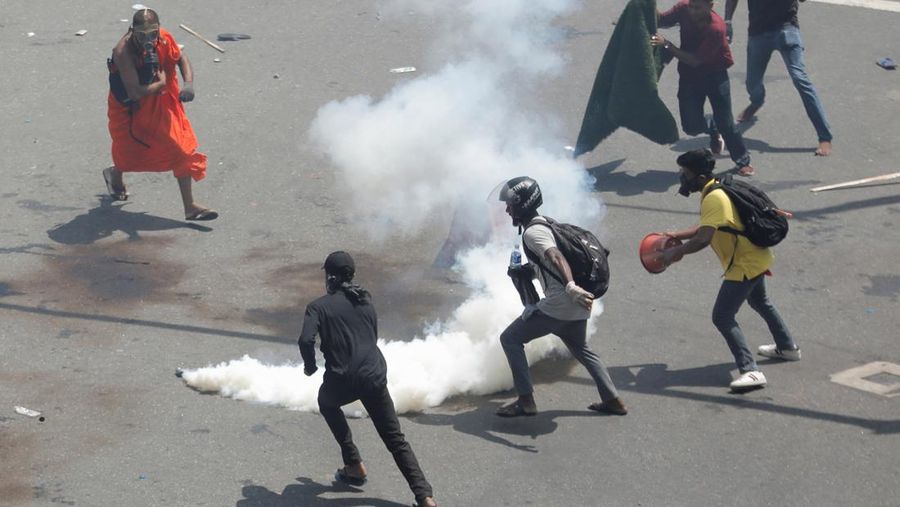 Demonstrators run from tear gas used by police during a protest demanding the resignation of President Gotabaya Rajapaksa, amid the country's economic crisis, near the president's residence in Colombo, Sri Lanka, July 9, 2022. REUTERS/Dinuka Liyanawatte